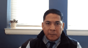 Rudy Soto from the USDA Office of External and Intergovernmental Affairs is shown in a video still against a blue wall and windows.